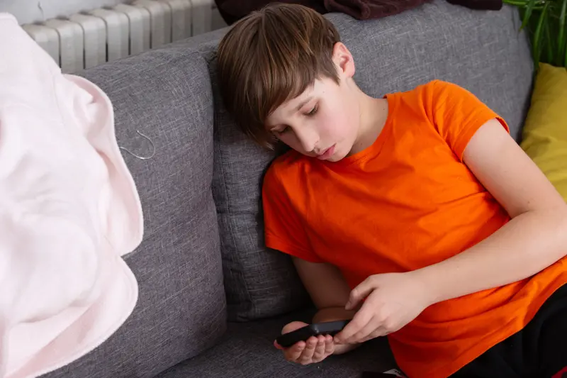 Gutt ser på telefon