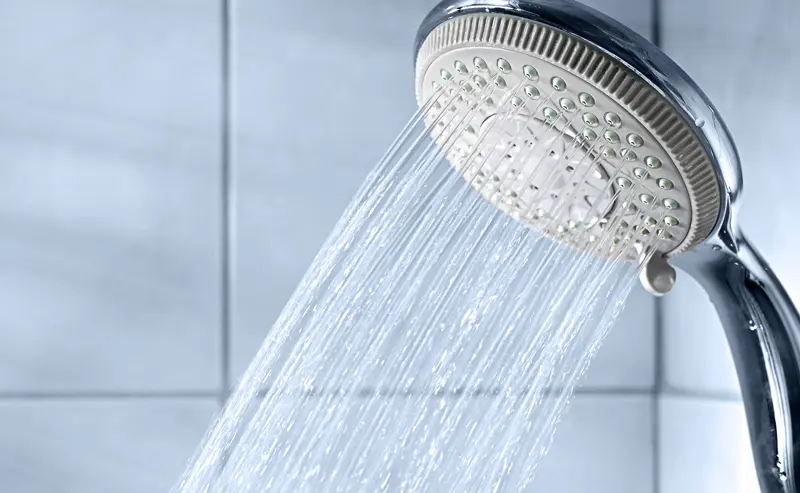 Fotografi av dusjhode med rennende vann