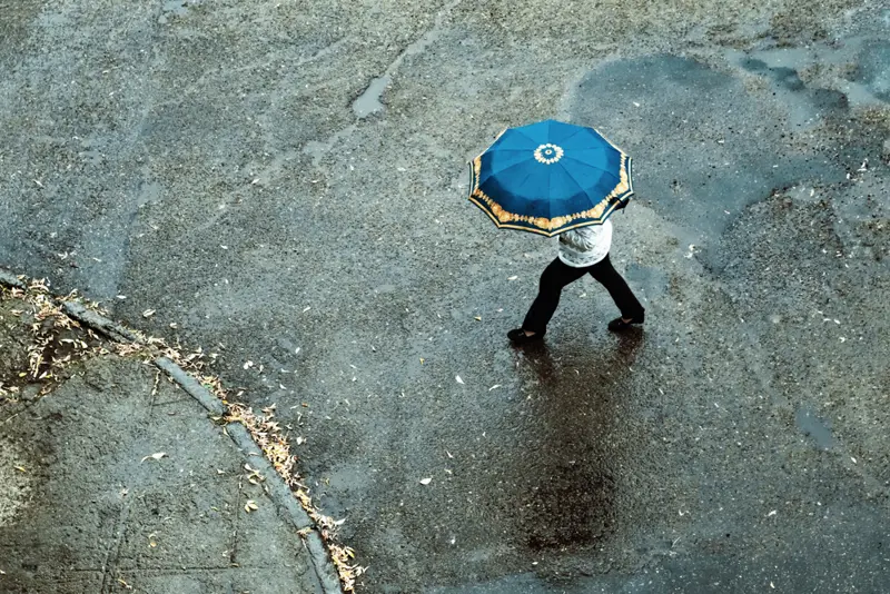 Person under paraply på gate