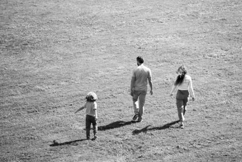 barn og foreldre som går på et jordet. Svart og hvitt bilde