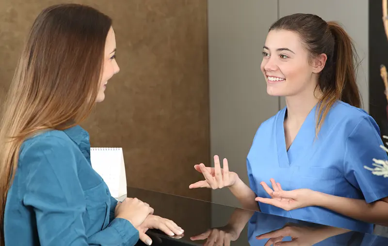 Sykepleier snakker med pasient. Bilde