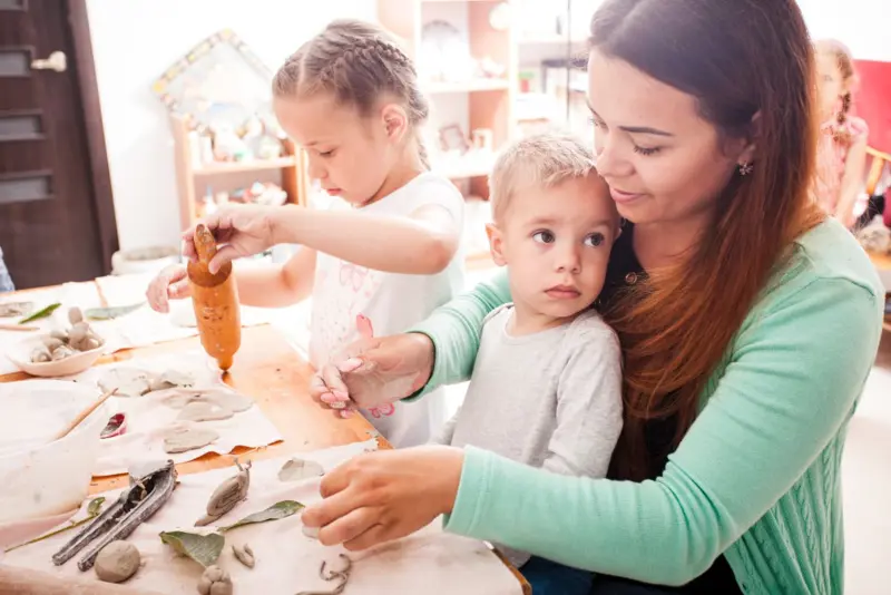Barnehageansatt leker med to barn