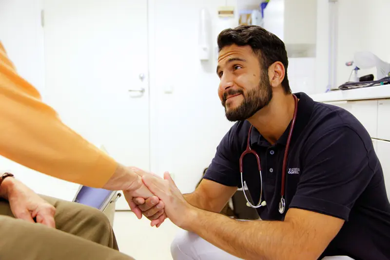 Lege viser omsorg for pasient. Bilde.