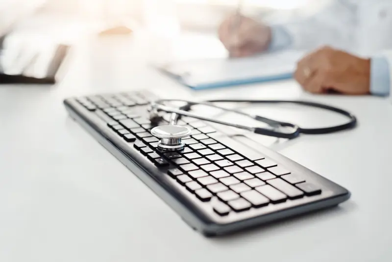 Tastatur og stetoskop på et bord