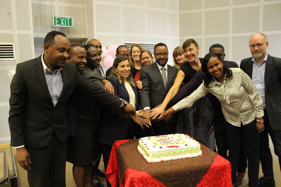 Photo of members of the consortium cutting a cake at the launch