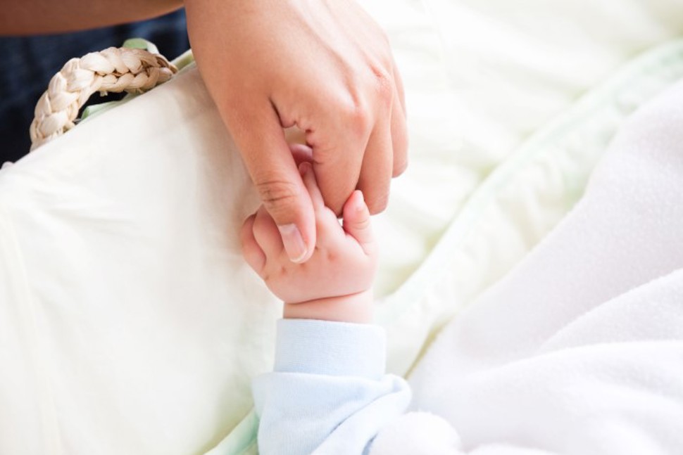 en mor holder en liten baby hånd i sin (bilde)