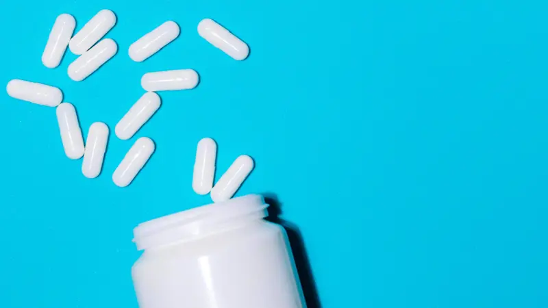 En pillebeholder med noen piller utenfor