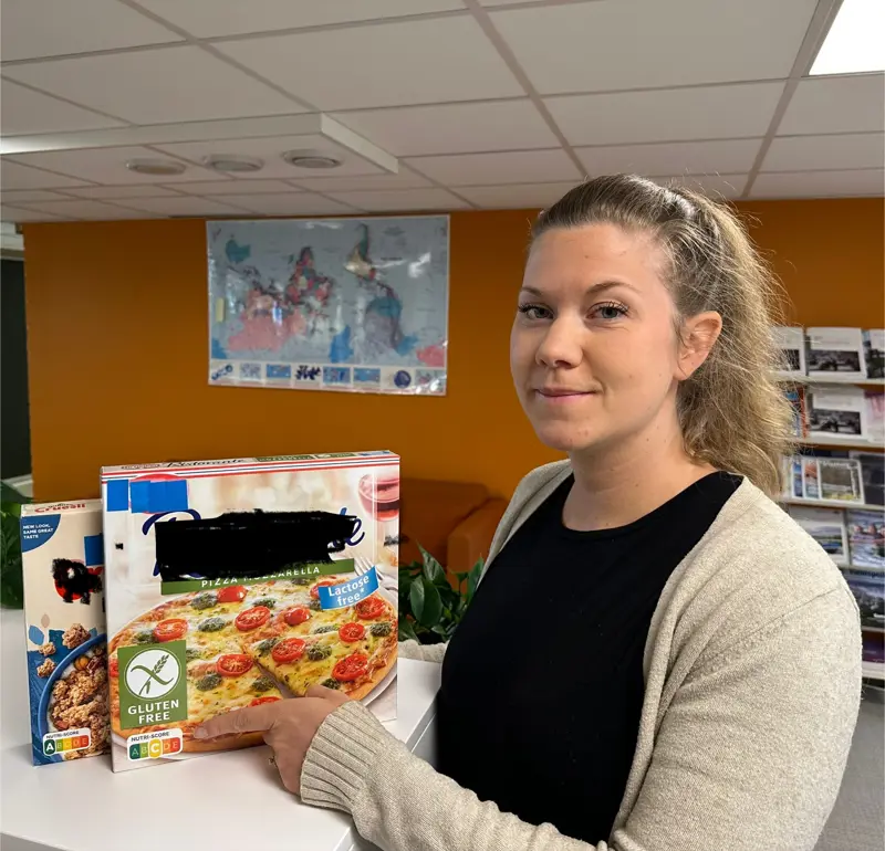 Her ser vi Anna Amberntsson peker på Nutri-Score merke på to importerte matvarer