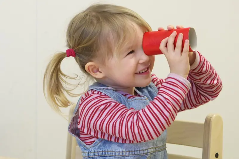 jente ser gjennom et rør