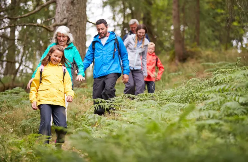 Illustrasjonsfoto av familie som går tur i skogen. 