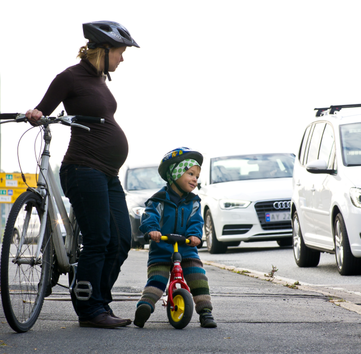 Mor og barn med sykkel i trafikken