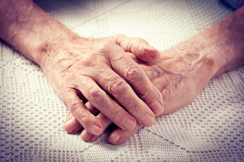 en eldre person som folder hendene
