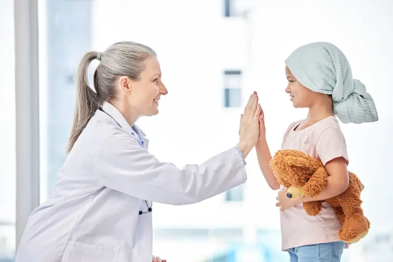 Health personell and child giving high fives to each other