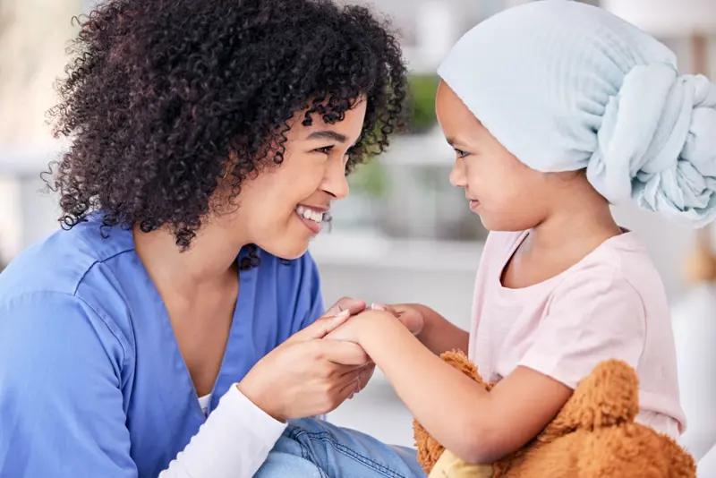 Children holding hands, one of them with a towel on her head