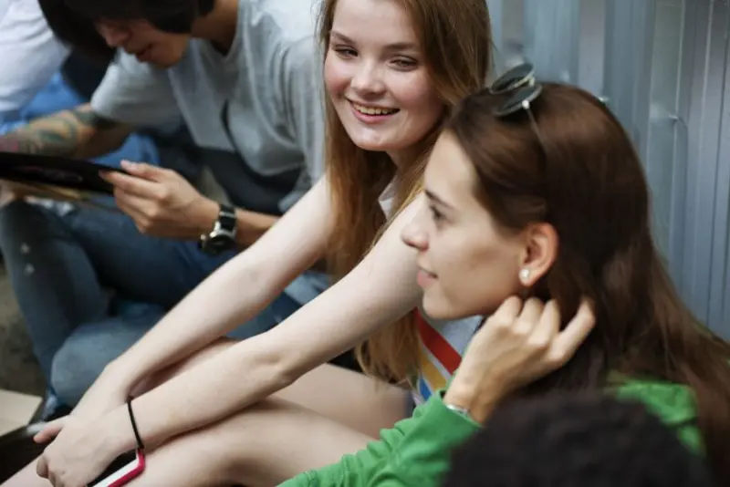 Bilde av to jenter og en gutt som snakker sammen