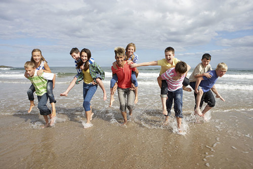 Ungdommer som løper sammen på en strand