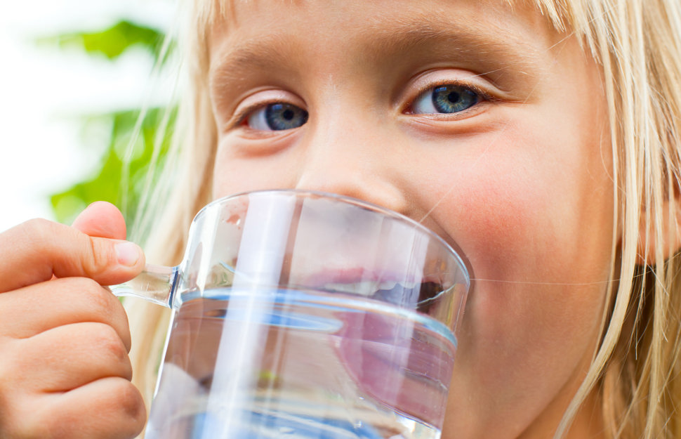 Barn som drikker vann fra glass