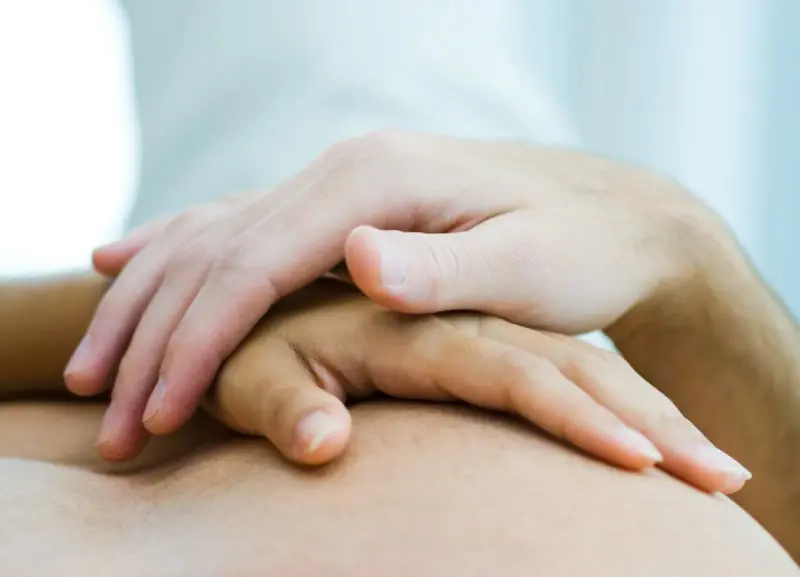 hender foldet over brystkasse