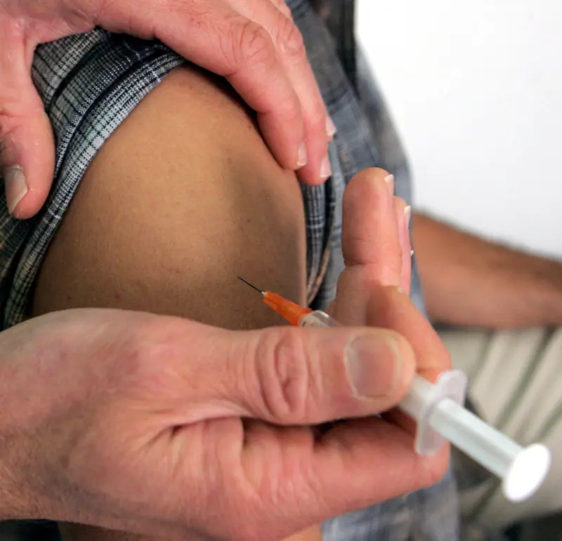 illustrasjon av sprøyte som blir gitt i overarm